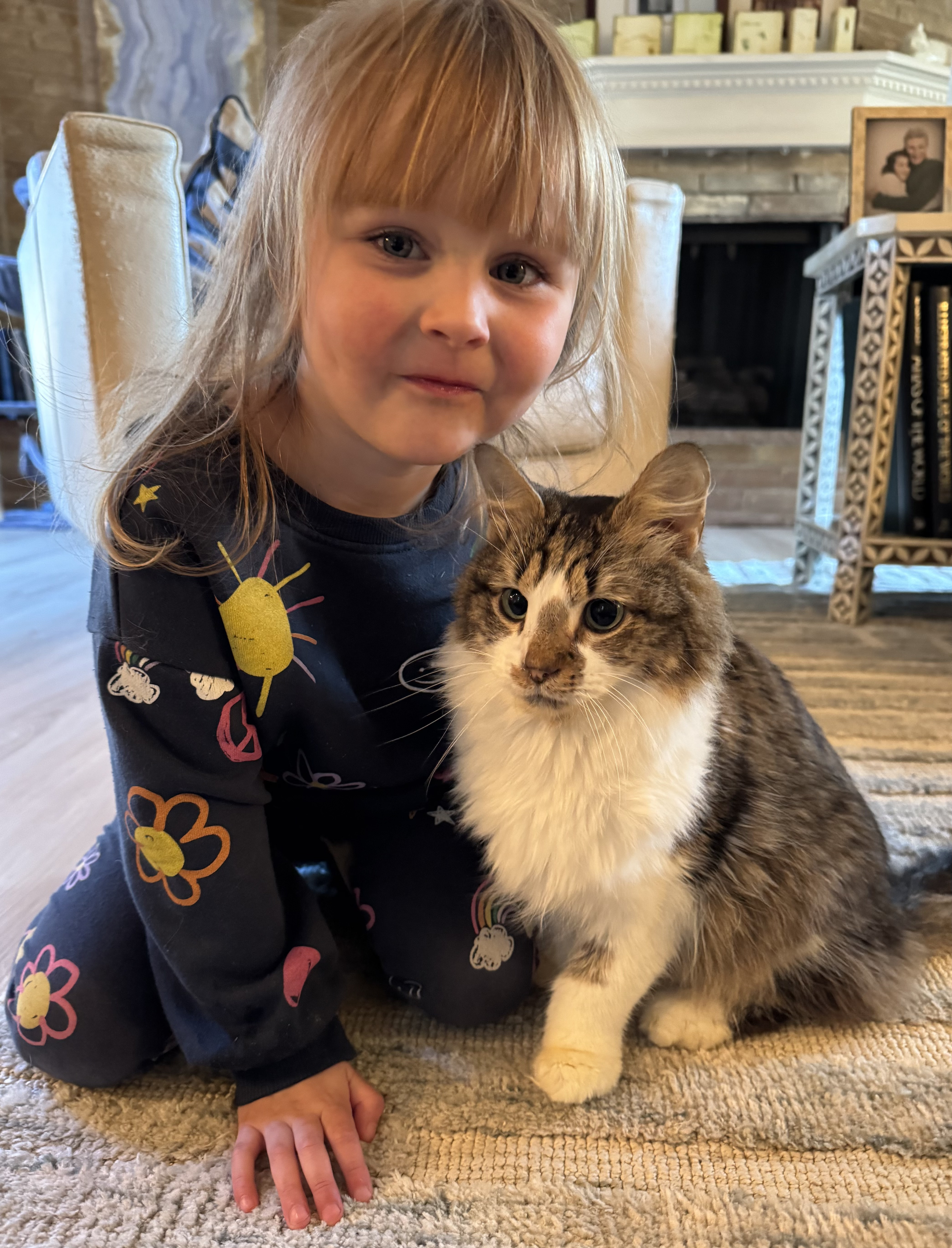 Child sitting next to a cat