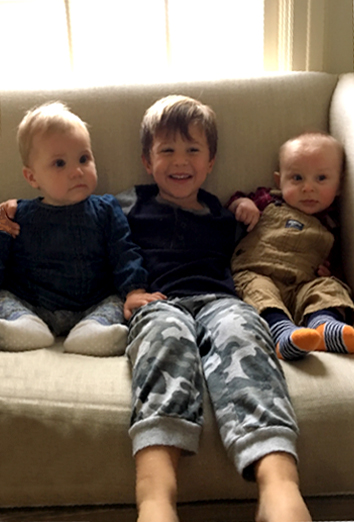 Three children sitting together and smiling